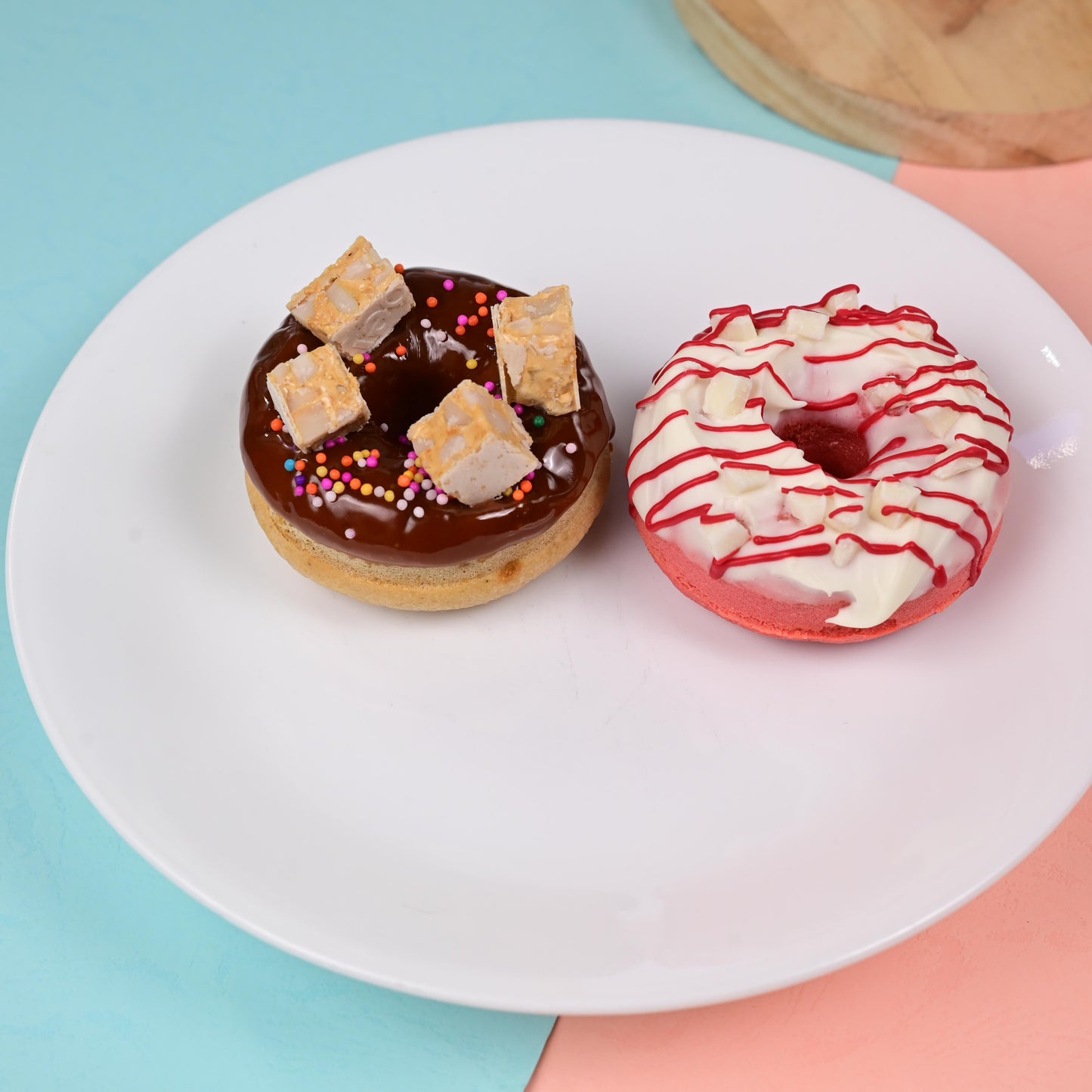 Two FITbelly donuts on a white plate with a colorful background