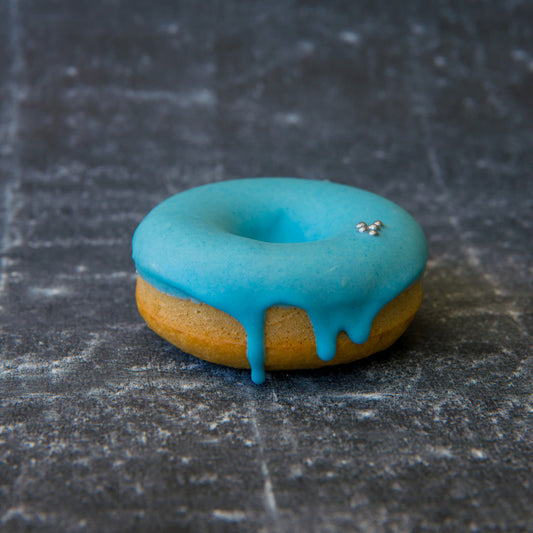FITbelly donut with blue glaze on a textured dark surface