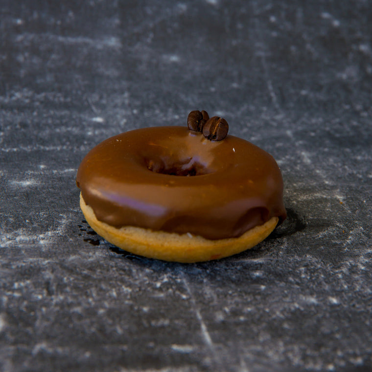 FITbelly donut with chocolate glaze and a star anise on a dark textured surface